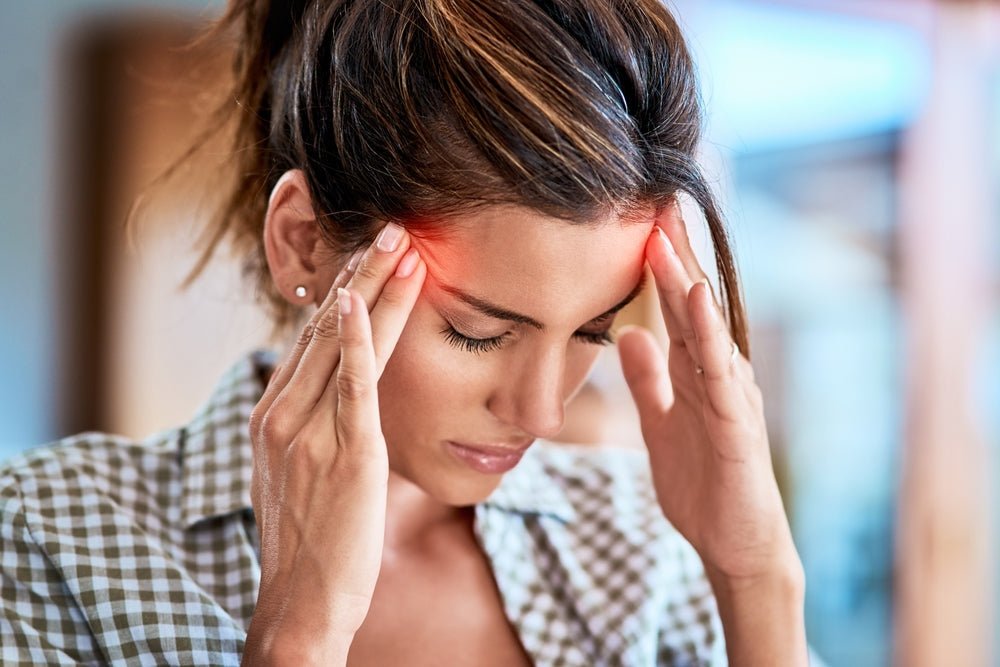 Woman holding sides of head headache